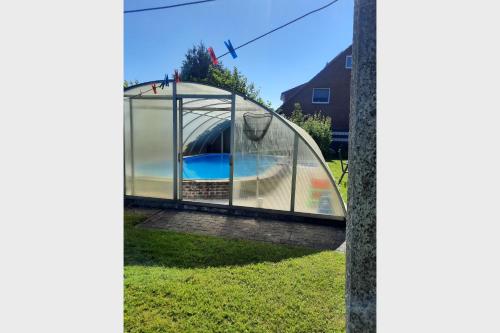 a glass house with a swimming pool inside at Nord-Strand in Norden