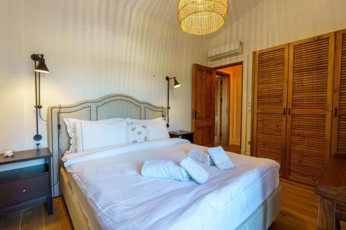 a bedroom with a bed with white sheets and pillows at Viento Villa in Cesme