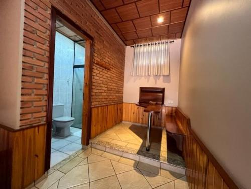 a bathroom with a toilet and a piano in a room at Status Motel Ourinhos in Ourinhos