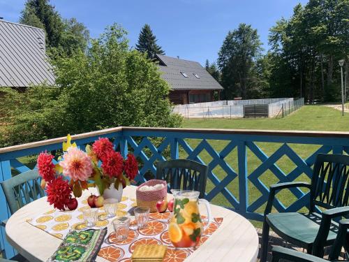 une table blanche avec un vase de fleurs et de fruits dans l'établissement Chalet nordique 214, à La Féclaz