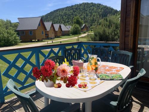 - une table blanche avec des fleurs sur le balcon dans l'établissement Chalet nordique 214, à La Féclaz