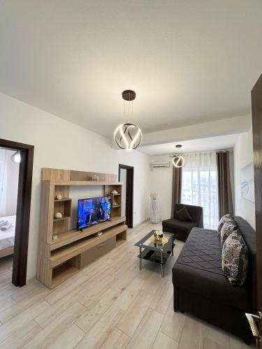 a living room with a couch and a flat screen tv at Apartmens Xhenis Lux in Ulcinj