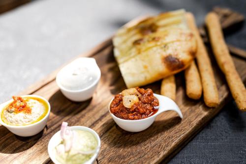 a tray of food with dip and bread and dips at Hotel Rebstock in Luzern