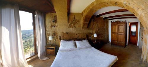 a bedroom with a bed and a large window at La Cava - Palazzo Pallotti in Bagnoregio