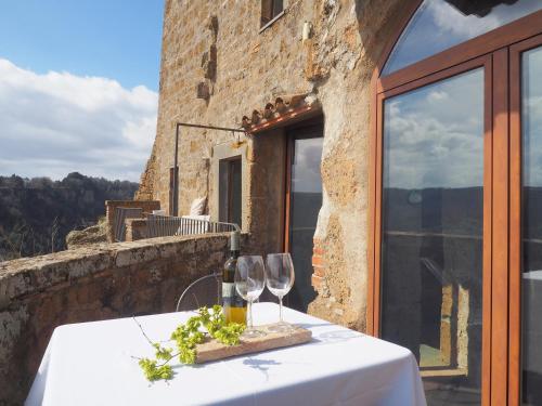 a table with wine glasses on top of a building at La Cava - Palazzo Pallotti in Bagnoregio
