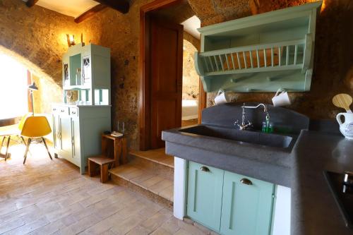 a kitchen with a sink and a counter top at La Cava - Palazzo Pallotti in Bagnoregio
