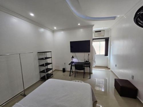 a bedroom with a bed and a desk and a tv at Apartamento Premium in Parintins