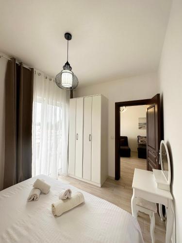 a bedroom with a white bed with towels on it at Apartmens Xhenis Lux in Ulcinj