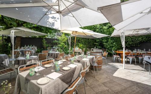a restaurant with tables and umbrellas on a patio at Hotel Rebstock in Luzern