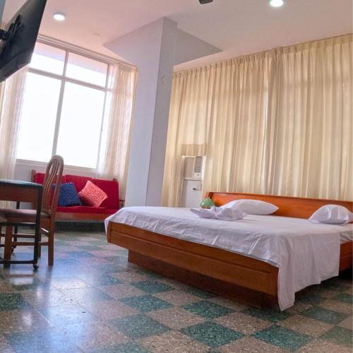 a bedroom with a large bed and a couch at Royal Park Hotel in Pucallpa