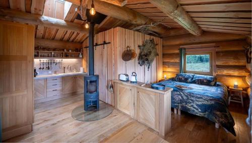 - une chambre avec un lit et une cuisinière dans une cabine dans l'établissement La cabane du trappeur, à Chennegy
