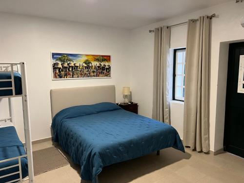 a bedroom with a bed with a blue blanket at Herdade da Moringa in Corte do Pinto