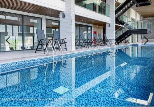 a swimming pool with chairs in a building at Fuji homestay Hạ Long in Ha Long