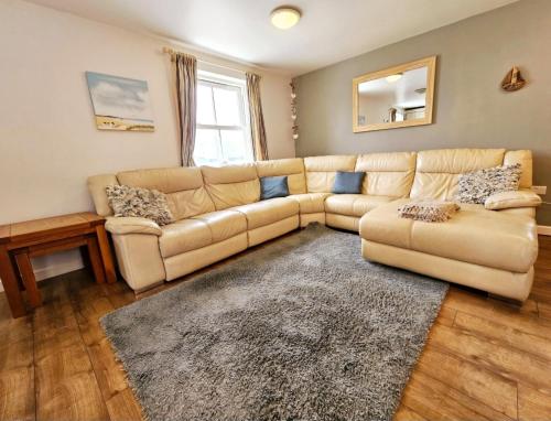 a living room with a couch and a rug at Bespoke coastal 2 bed cottage with free parking in Ilfracombe