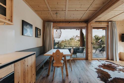 a kitchen and dining room with a table and chairs at Presulis Hideaway Apartments & Restaurant in Fi&egrave;