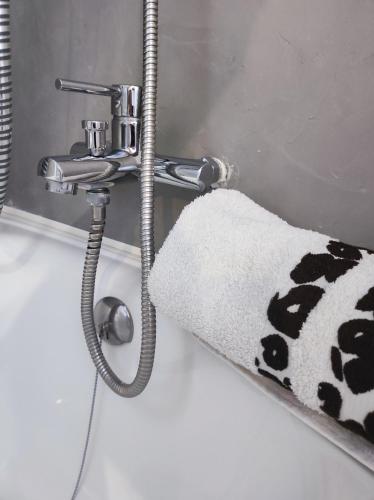 La salle de bains est pourvue d'un lavabo et d'une serviette suspendue à un robinet. dans l'établissement LE COURANT D'HUCHET, à Moliets-et-Maa