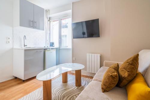 un salon avec un canapé et une table dans l'établissement Appartement au cœur de Paris Montparnasse, à Paris