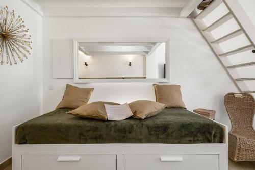 een slaapkamer met een bed met een spiegel aan de muur bij Cap d'Agde Suit'Appart T2 Pinede 31 M2 in Cap d'Agde