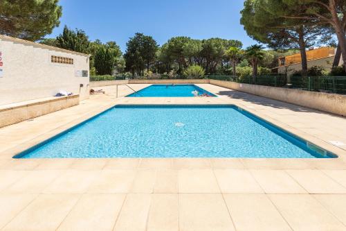 une grande piscine avec de l'eau bleue dans l'établissement Cap d'Agde Suit'Appart T2 Pinede 31 M2, au Cap d'Agde