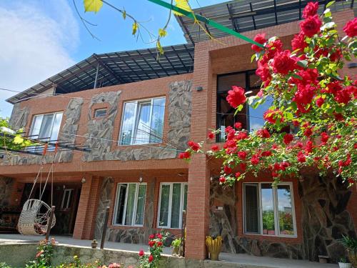 un edificio in mattoni con fiori rossi di fronte di Panorama RABATI a Akhaltsikhe