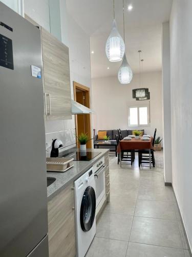 a kitchen with a washer and dryer and a living room at uim mediterraneio PB vicente andres estelles wifi in Puerto de Sagunto