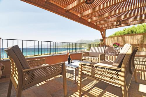 a patio with two chairs and a table with a view of the ocean at Résidence Saint-Jean in Saint-Florent