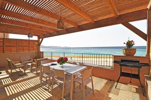 a balcony with a table and chairs and the ocean at Résidence Saint-Jean in Saint-Florent