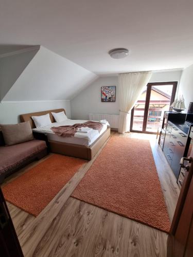 a bedroom with a bed and a couch at Pensiunea Azurul in Sovata