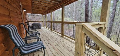 a porch with three chairs on a wooden deck at HotTub, Arcade - Less than 15 min to all RRG Attractions in Rogers