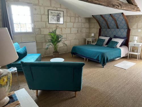 a bedroom with a bed and a couch and chairs at Beaulieu La Source in Saumur