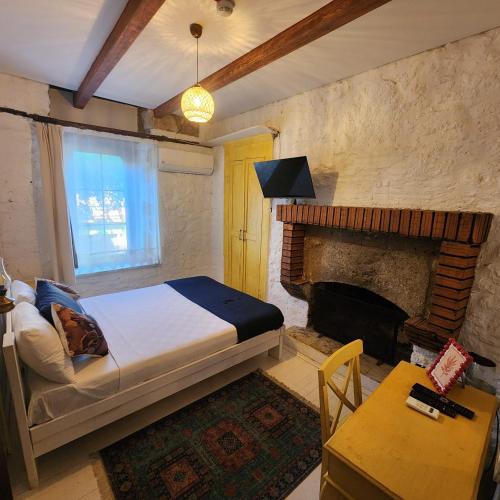 a bedroom with a bed and a fireplace at Kapela Taş Otel Alaçatı in Çeşme