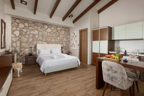 a bedroom with a bed and a stone wall at Vintage Suites Trikala in Tríkala