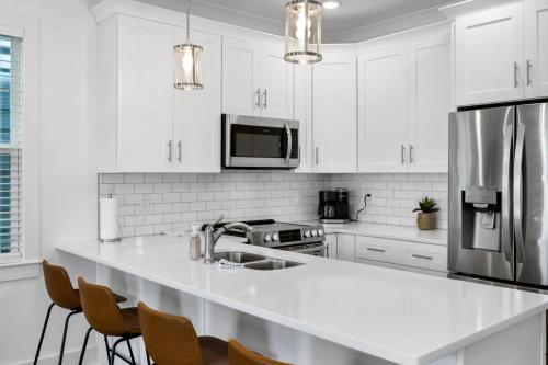 a kitchen with white cabinets and a kitchen island with chairs at The Lakeside Landing in Nashville