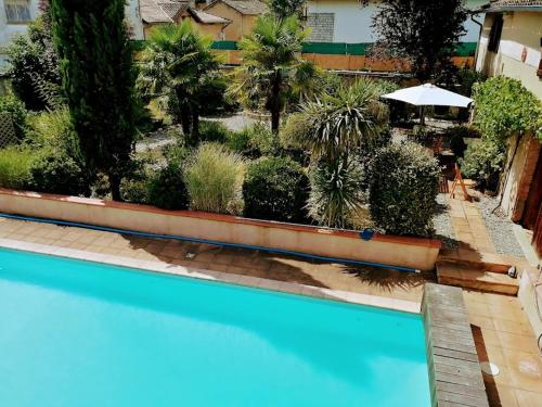 une vue sur une piscine avec un jardin dans l'établissement Maison pour 2 personnes avec piscine privative, à LʼIsle-en-Dodon