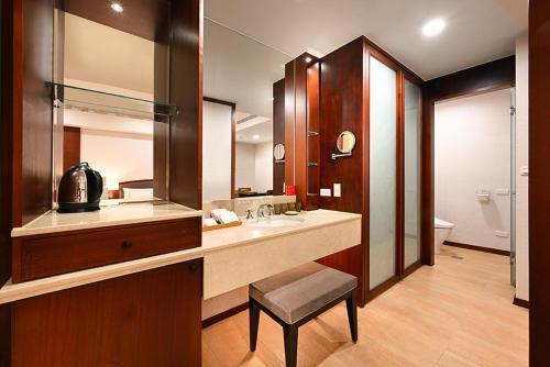 a bathroom with a sink and a mirror and a stool at Alishan Hotel in Xianglin