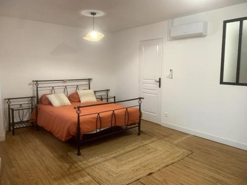 une chambre avec un lit avec un couvre-lit orange dans l'établissement Charmante Maison De Ville, à Barbaste