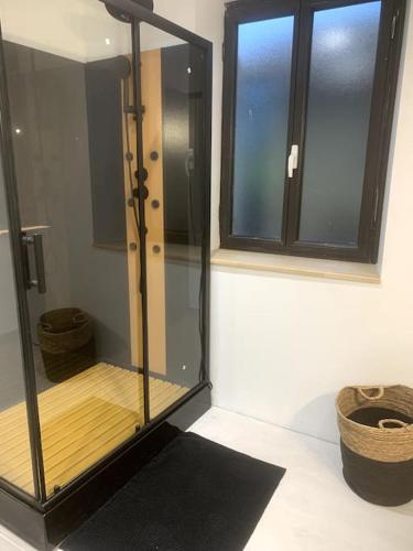 La salle de bains est pourvue d'une douche en verre et d'une fenêtre. dans l'établissement Charmante Maison De Ville, à Barbaste
