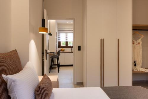 a bedroom with a bed and a door to a kitchen at Irisma Luxury Villa with private pool in Archanes