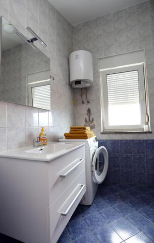 a bathroom with a washing machine and a sink at Babsi in Pula