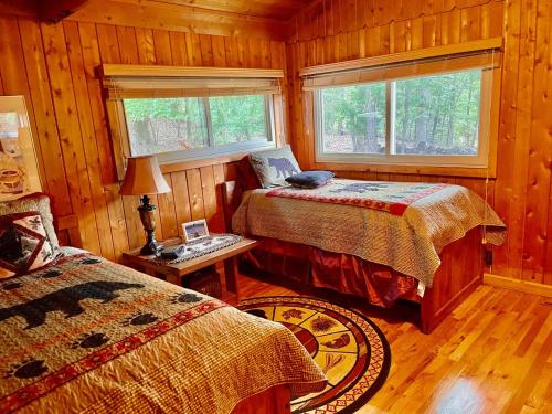 a bedroom with two beds and a table with a lamp at Lake Escape To An Elegant 4 Br Home in Huddleston