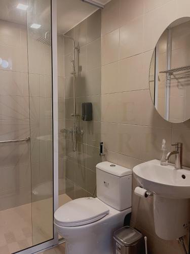 a bathroom with a toilet and a sink and a shower at At Five Sierra - 1BR Condo in One Regis Megaworld in Bacolod