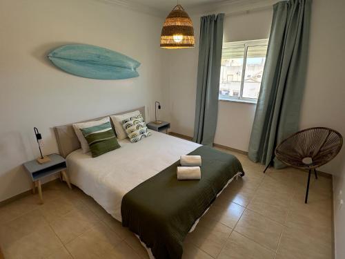 1 dormitorio con 1 cama y 1 pez azul en la pared en Casa Janivo, en Armação de Pêra