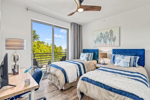 a bedroom with two beds and a desk at Waterfront, Pet-Friendly Condo with Pool, Spa, and Fitness Center near Downtown Sarasota in Sarasota