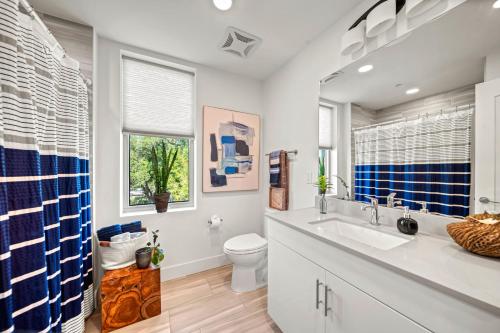 a bathroom with a sink and a toilet and a window at Waterfront, Pet-Friendly Condo with Pool, Spa, and Fitness Center near Downtown Sarasota in Sarasota