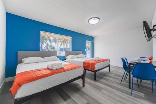 Dos camas en una habitación con una pared azul. en Unit with Balcony and Parking at the beach -M45, en Hollywood