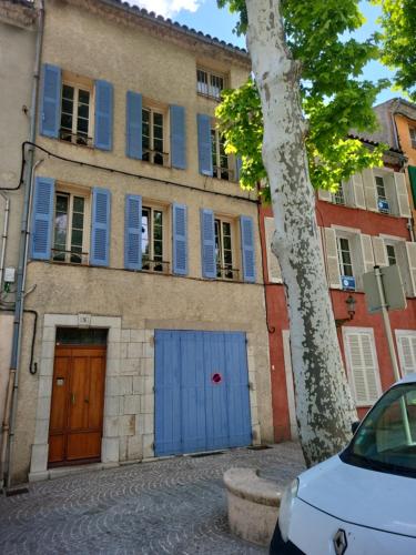 un bâtiment avec volets bleus et une voiture garée devant dans l'établissement Villa lorguaise, à Lorgues