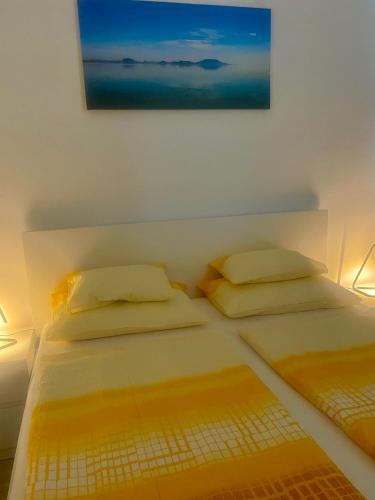 two beds in a room with two lamps and a painting at Vízparti Apartman in Siófok