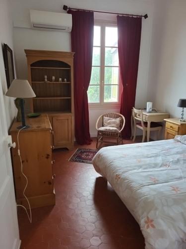 une chambre avec un lit, un bureau et une fenêtre dans l'établissement Villa lorguaise, à Lorgues