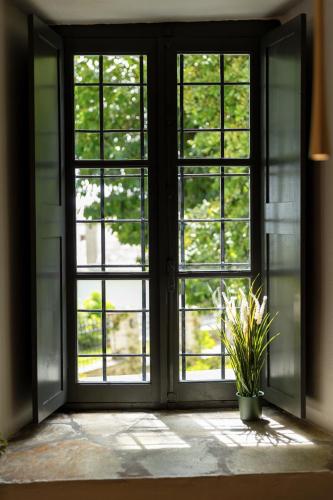 an open door with a potted plant in a room at Kenta Mountain Hotel & Gastrobar in Portariá