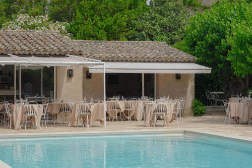 - un groupe de tables et de chaises à côté d'une piscine dans l'établissement Hôtel La Figuière, à Saint-Tropez